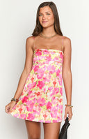 Fashion model showcasing a beautiful pink and yellow floral print mini slip dress- featuring delicate spaghetti straps and a flowing A-line silhouette- ideal for warm weather.