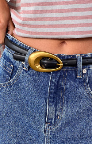 black belt with gold buckle styled on model wearing denim bottoms and striped top