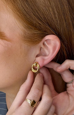 A close-up side profile of a model wearing the Hollie Gold Chunky Hoop Earring