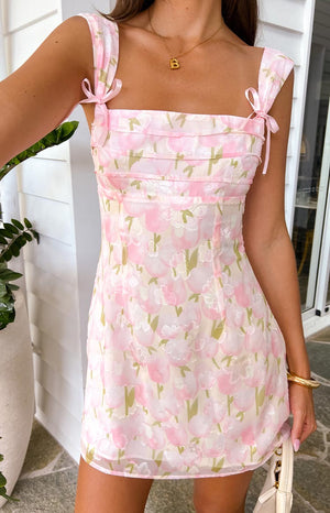 girl wearing a pink mini dress with a pink floral pink pattern and tiered bust details