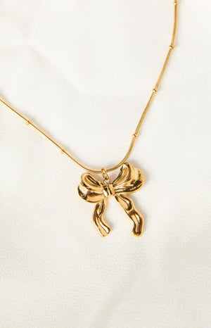 a gold bow knot pendant necklace with dot chain details