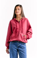 An oversized red zip-up hoodie with a drawstring hood and a large front kangaroo pocket.