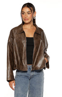 Our model wears a slightly oversized dark brown faux leather jacket with a relaxed fit. The jacket features a classic collar dropped shoulders and a silver front zipper. It has a cropped or cinched hemline and is styled open or can be layered over any of your favorite top.