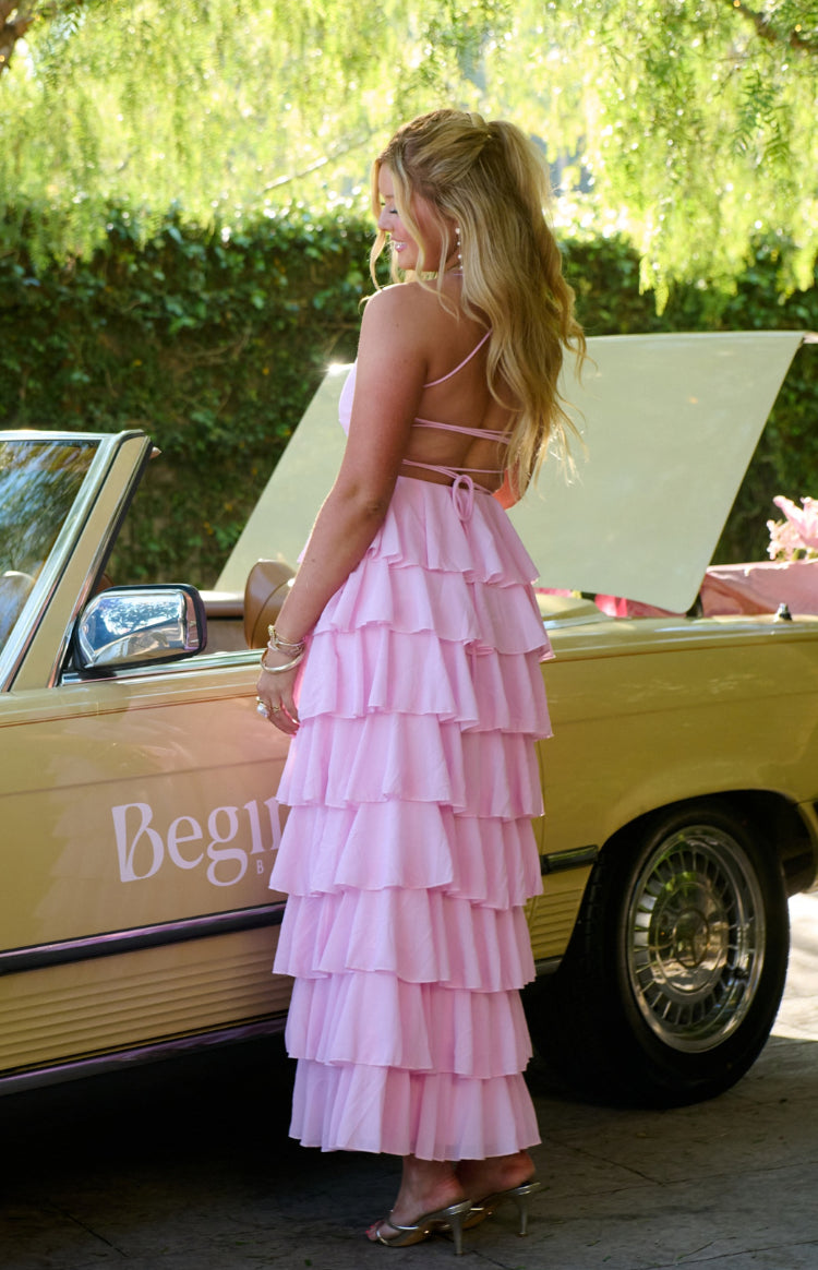 Side view of the pink tiered ruffle maxi dress showing the criss-cross back straps and full skirt