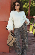 Cream chunky knit sweater with a wide boat neck, dropped shoulders, and voluminous cuffed sleeves