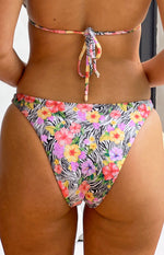 Rear view of white zebra print bikini bottoms with colourful floral pattern and cheeky cut