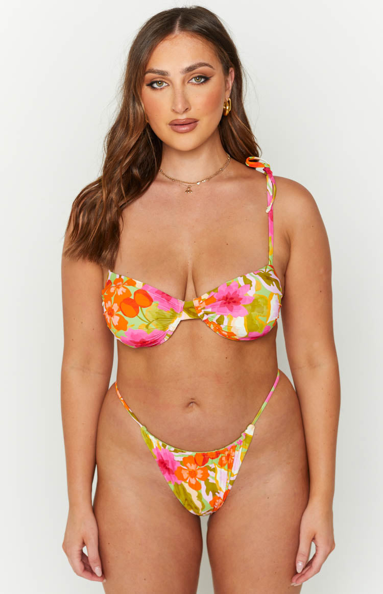 Front view of a high-cut floral print bikini bottom with thin side straps and pink, orange, green flowers