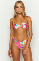 Back view of white floral high waisted bikini bottom with vibrant pink yellow green flowers and cheeky high cut leg