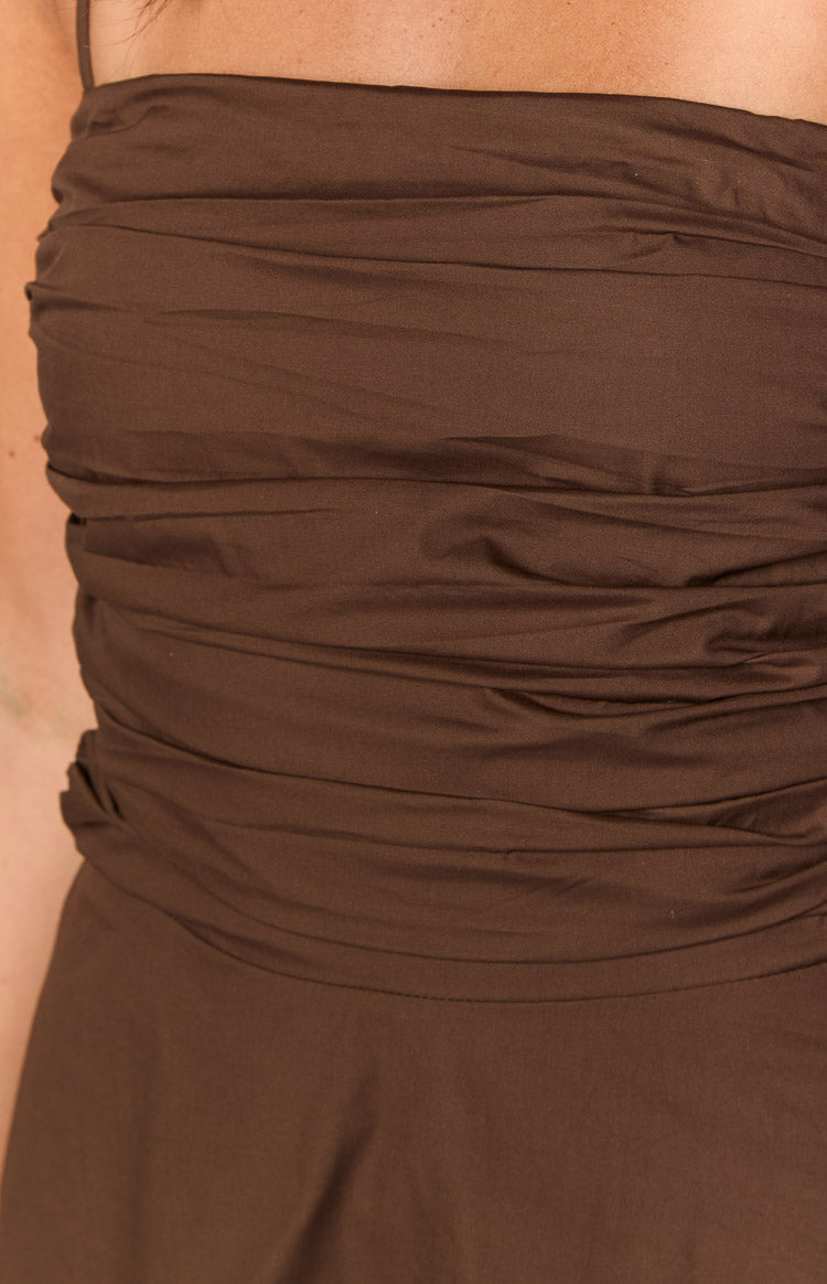 Close-up of the horizontal ruching detail across the bust and waist of a brown mini dress