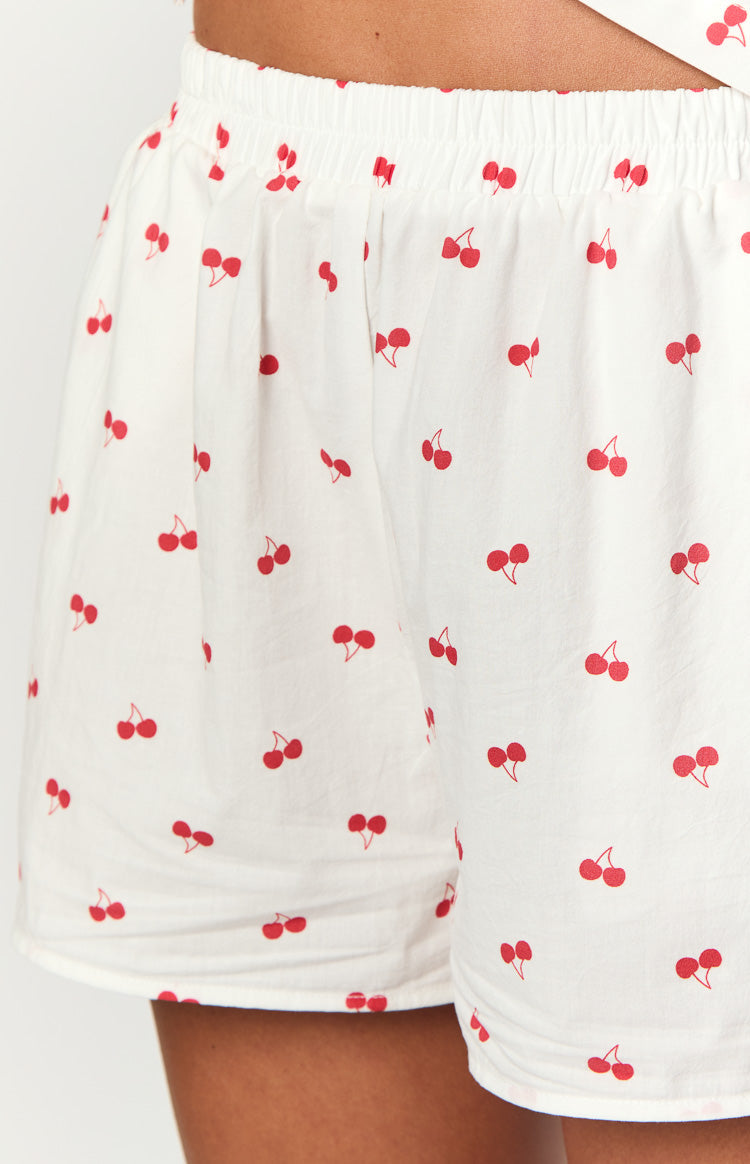 Close-up of the white pajama shorts with red cherry print and elasticated waistband