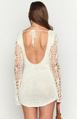 Rear view of a white crochet mini dress with a low scoop back, tie detail, and long floral crochet sleeves
