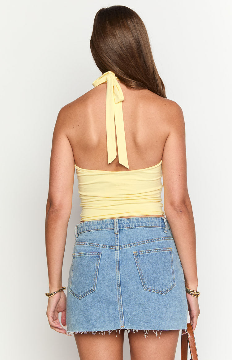 Rear view of a yellow fitted crop top showing the tie-back halter neck detail