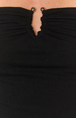 Close-up of the black ribbed knit top's ruched V-neckline with two gold sphere details