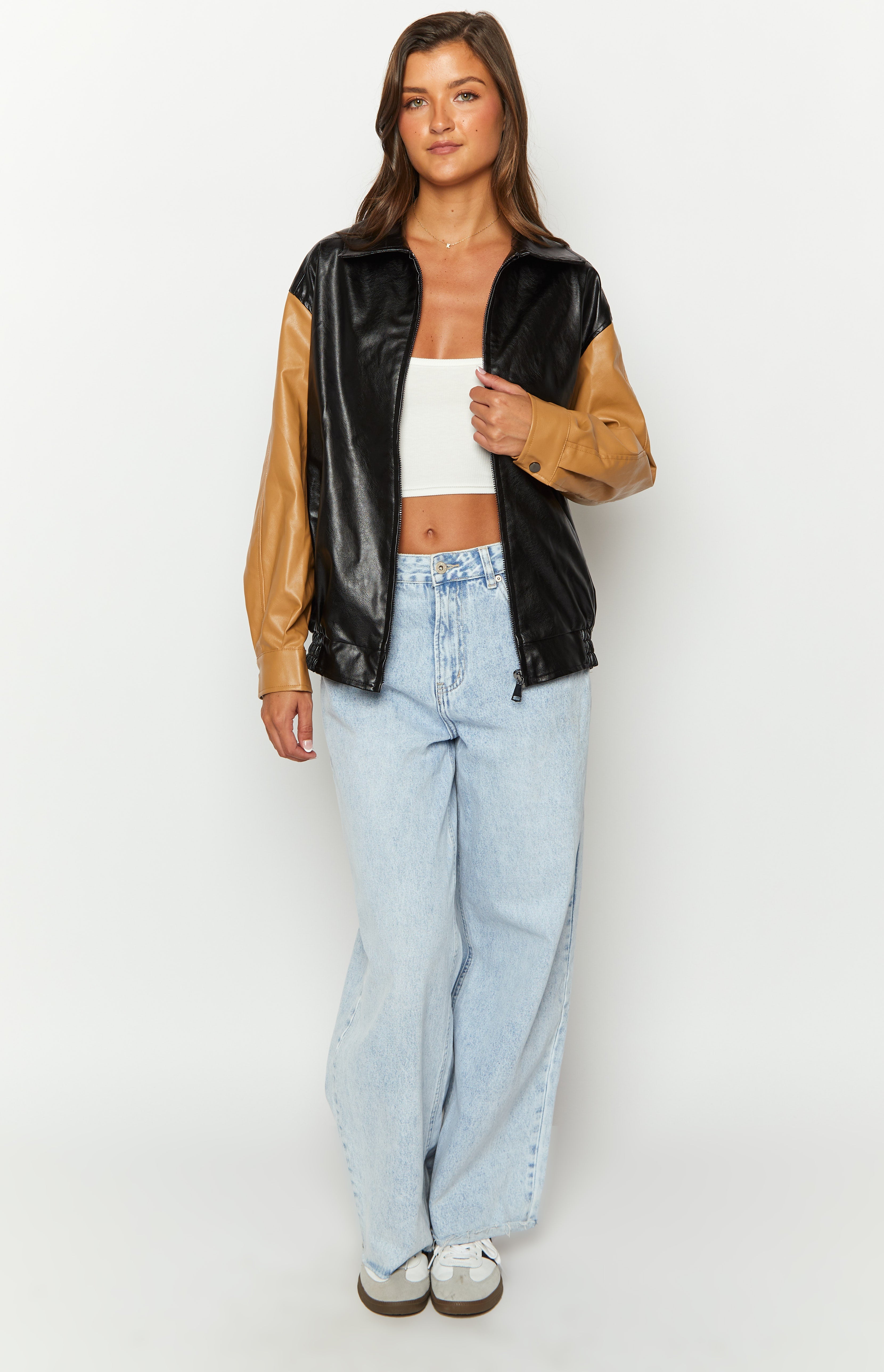 Black PU bomber jacket with tan brown contrast sleeves, unzipped showing the collar and ribbed hem