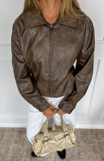 Vintage brown PU bomber jacket with a collared neckline, full zip front, and buttoned cuffs