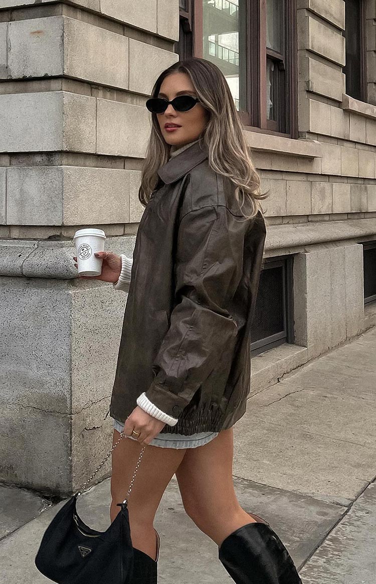 Faux leather oversized brown bomber jacket. Worn by model walking the street. 