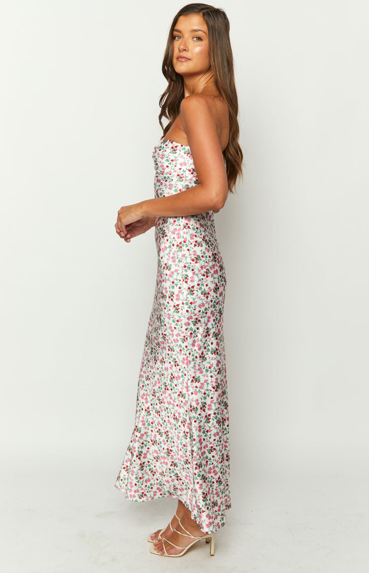 Side view of a white floral strapless maxi dress with a fitted bodice and flowy skirt