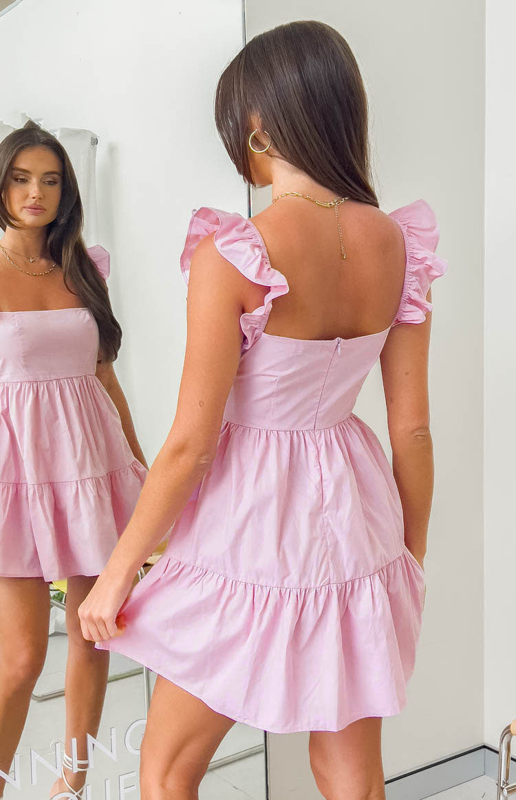 Rear view of a pink mini dress with a square back, ruffled shoulder straps, and tiered skirt