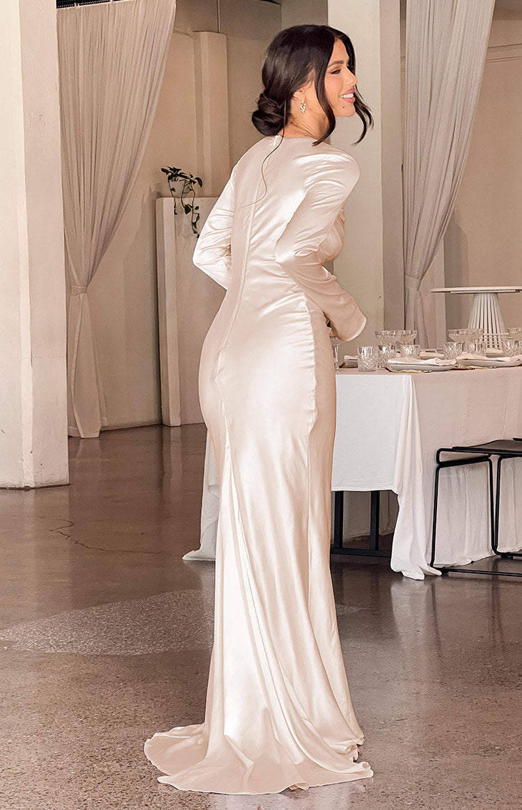 Rear view of a cream satin long sleeve maxi dress with a fitted bodice and flowing train