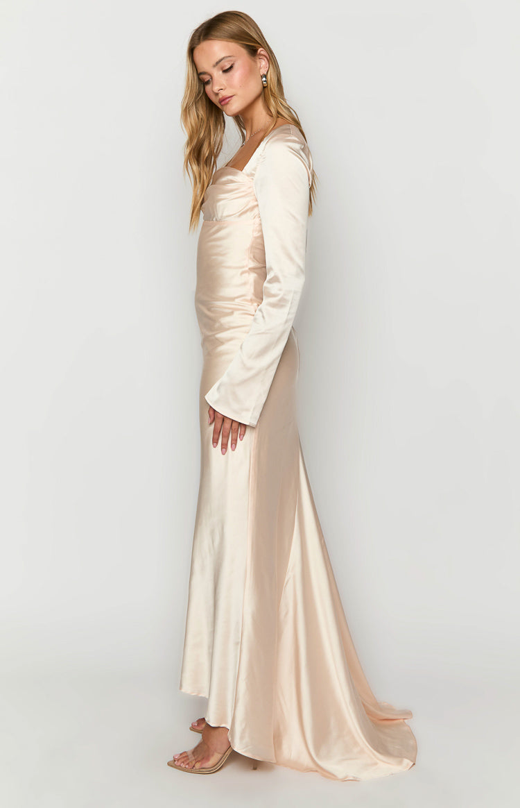 Side view of a cream satin long sleeve maxi dress showing the fitted bodice and flowing skirt