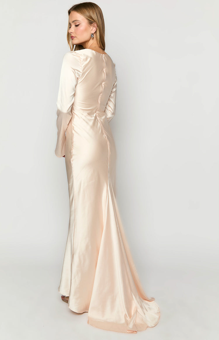 Rear and side view of a cream long sleeve maxi dress with a fitted silhouette, side ruching, and floor-length hem
