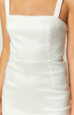 Close-up of the fitted white mini dress showing the square neckline, thick straps, and side zipper detail