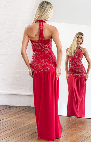 Rear view of a red halter maxi dress with a tied neck and intricate white and red beading on the bodice
