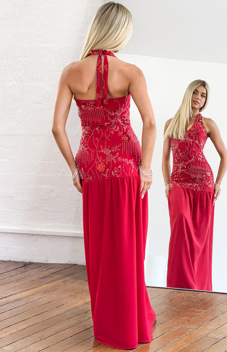 Rear view of a red halter maxi dress with a tied neck and intricate white and red beading on the bodice