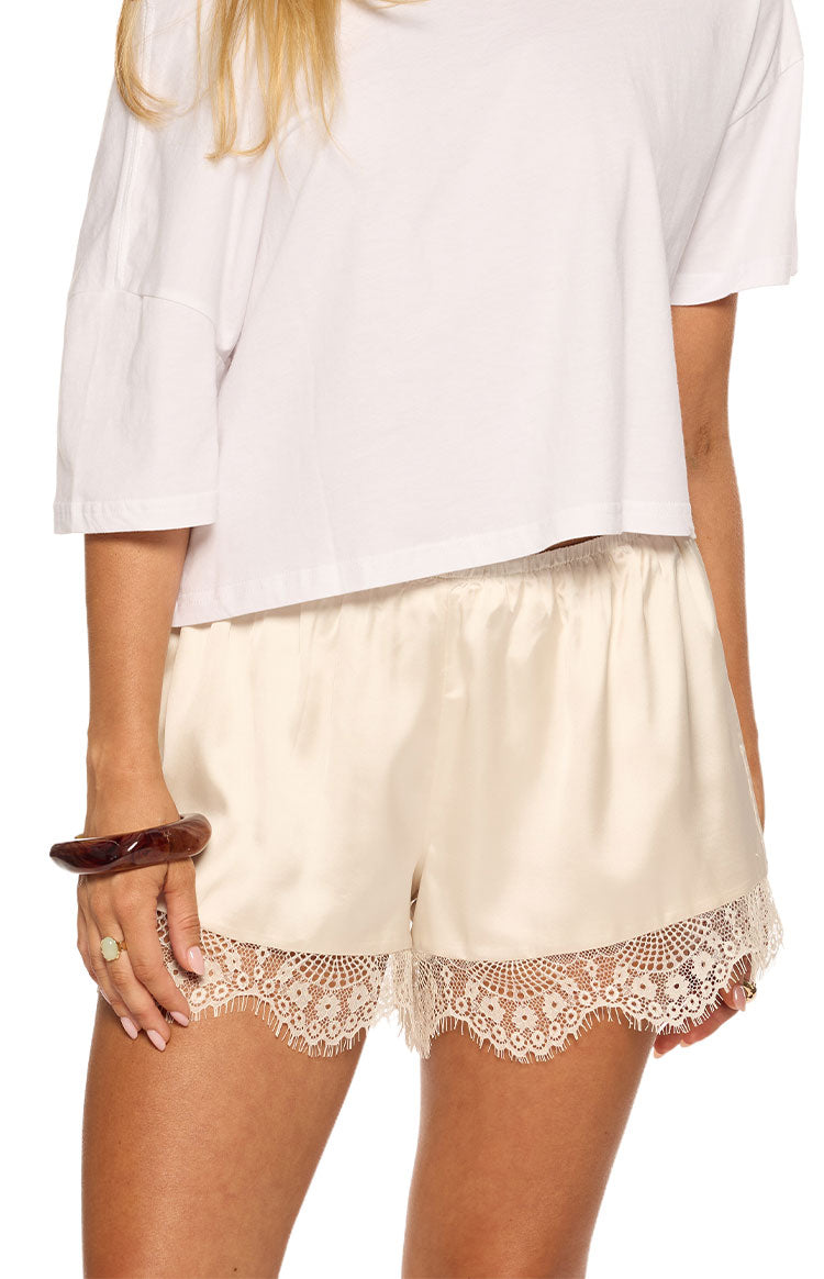 Front view of cream satin shorts showing the elasticated waist and scalloped lace hem