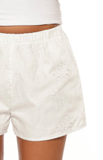 Close-up of the elasticated waist and white floral broderie anglaise shorts