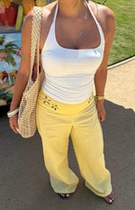 Close-up of the yellow wide-leg pants featuring floral cutouts along the high waistband