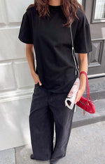 Front view of a black crew neck tee with relaxed fit and short, wide sleeves