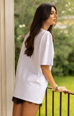 Side view of a white oversized short sleeve tee with a relaxed fit and dropped shoulders