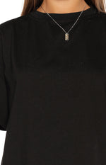Close-up of the black crew neck tee showing the soft jersey knit fabric