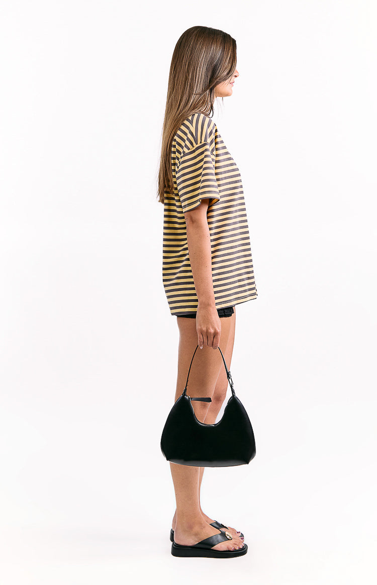 Side view of a yellow and dark grey striped oversized tee with short sleeves and a relaxed fit