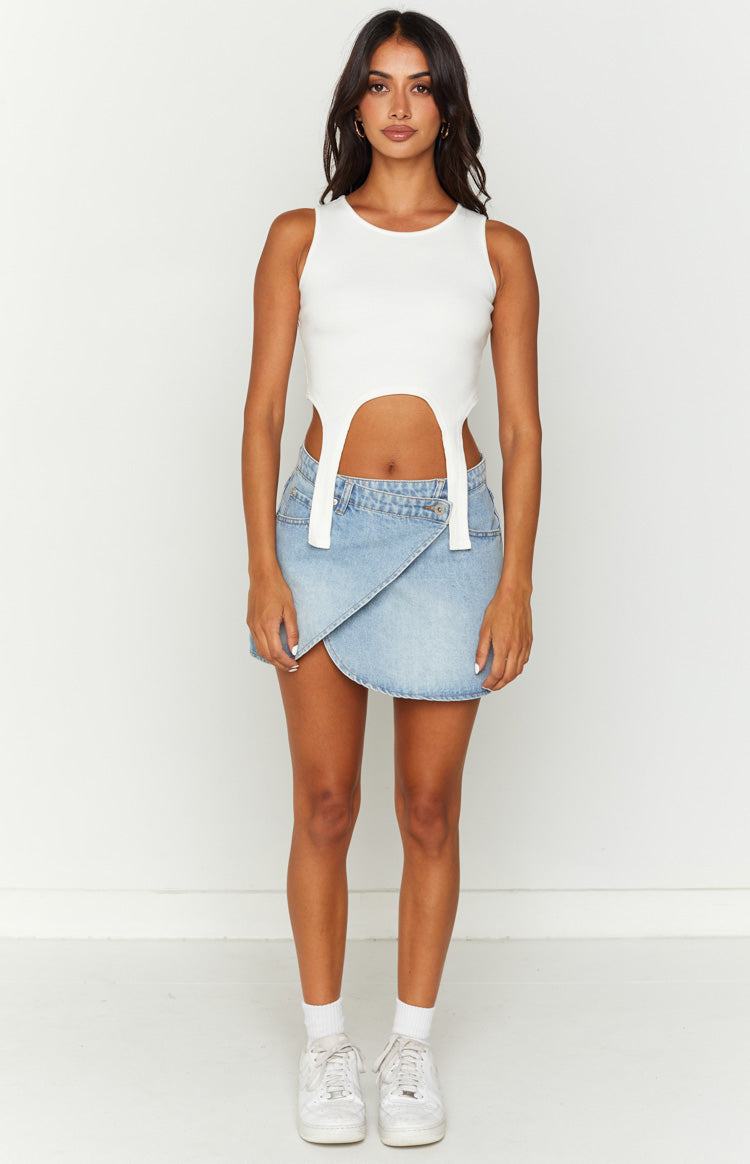Light blue denim mini skirt featuring an asymmetrical wrap design and a single button closure