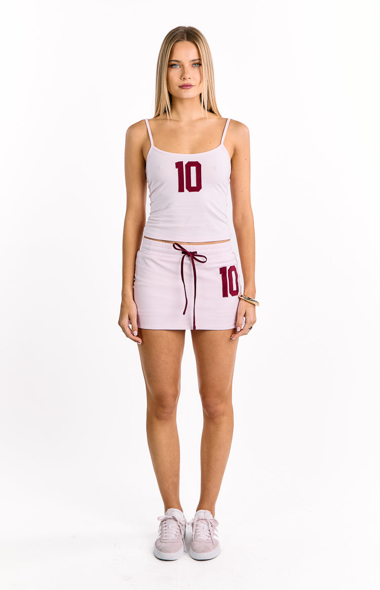 Pink jersey mini skort featuring a dark red drawstring waist and a matching number 10 graphic on the left thigh