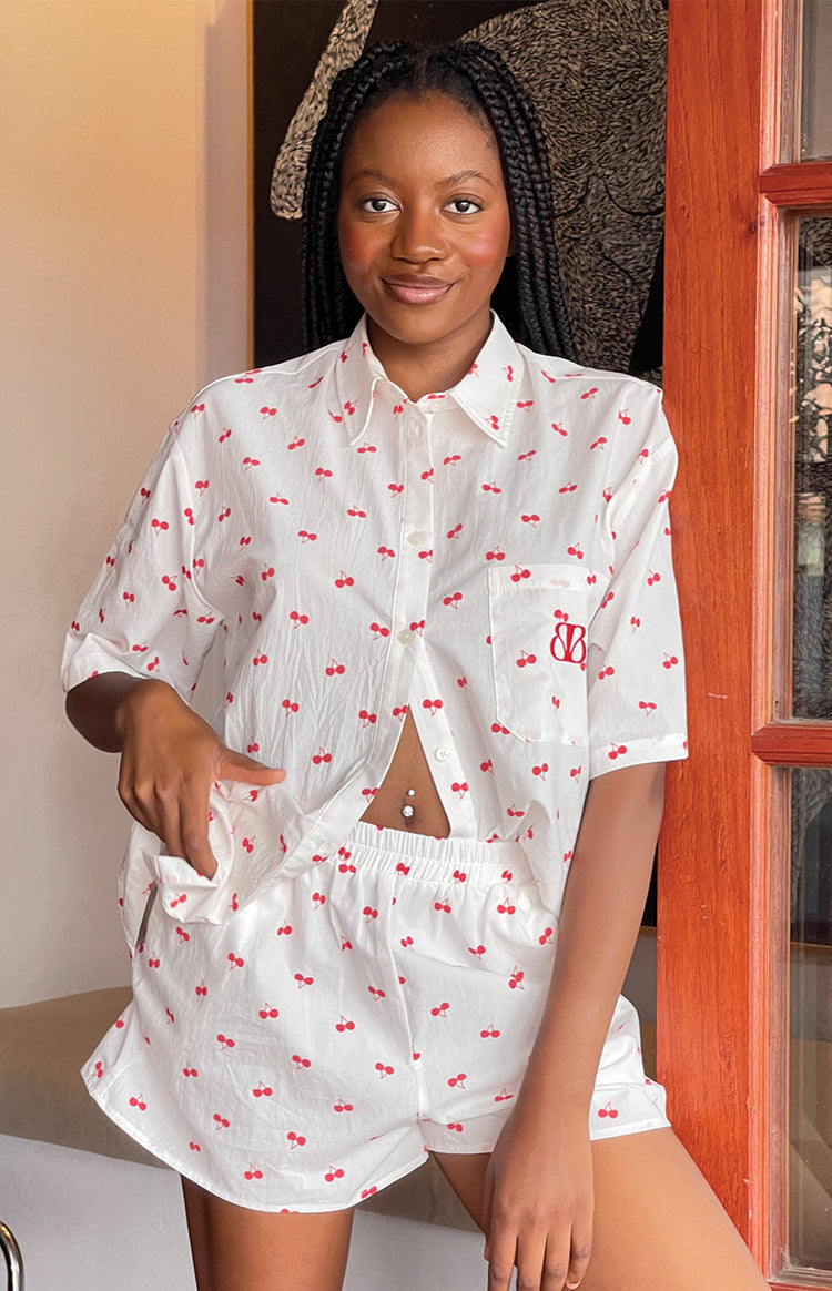 White cherry print pajama shorts with elasticated waist and matching short sleeve button-up shirt