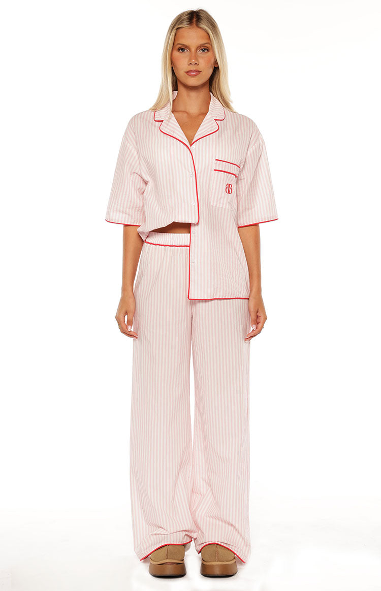 Pink and white striped wide-leg pajama pants with red piping on the cuffs and elasticated waist