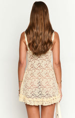 Back view of a cream floral lace mini dress with a delicate lace pattern and a ruffled hemline