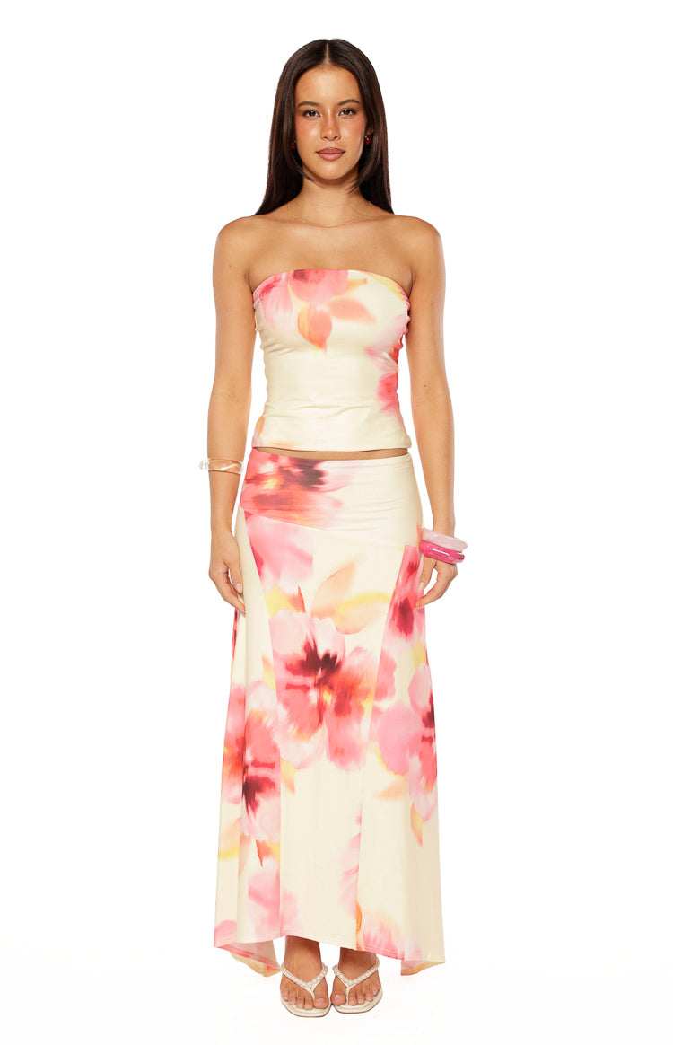 Full front view of a yellow and pink floral print maxi skirt with a flowing silhouette and hanky hem