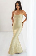 Full length view of the gold strapless bandage maxi dress with a sweetheart neckline and a flared trumpet skirt