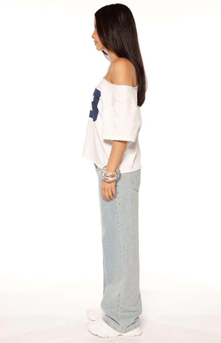 Side view of a white oversized off-shoulder tee with short sleeves and a blue graphic print