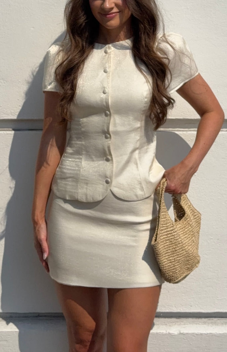 Front view of a fitted cream organza mini skirt with a smooth finish