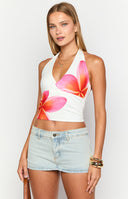 girl wearing a white halter neck top with frangipani print details