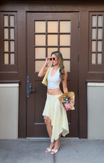 White polka dot crop top with a deep V-neck halter neckline and fitted silhouette