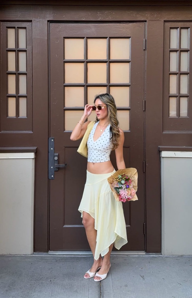 White polka dot crop top with a deep V-neck halter neckline and fitted silhouette