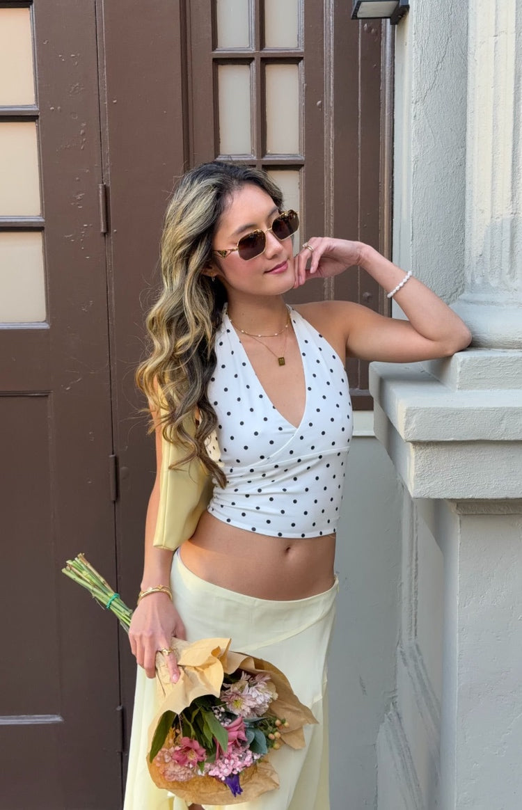 White polka dot crop top with a halter neck and deep V-neck wrap front