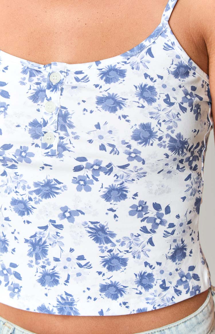Close-up of the white singlet with blue floral print and front button placket