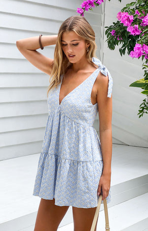 Beginning Boutique Angel Girl Blue Gingham Floral Mini Dress blue gingham V-neck mini dress with tie shoulders and tiered ski